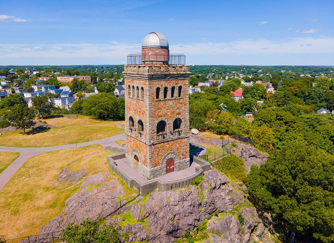 About Our Agency - View of a Historical Astronomy Observation Brick Tower Surrounded by Green Trees in Lynn Massachusetts